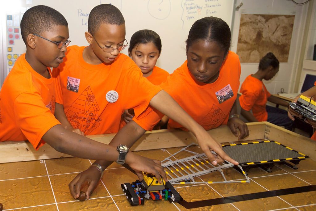 Kids exploring space technology through lego kit models