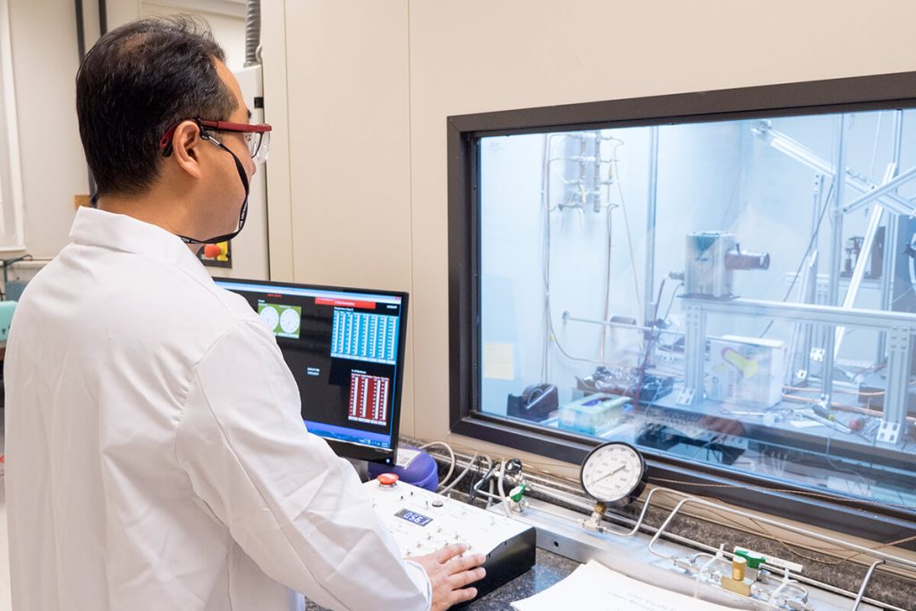 Scientist monitors test of machinery from window