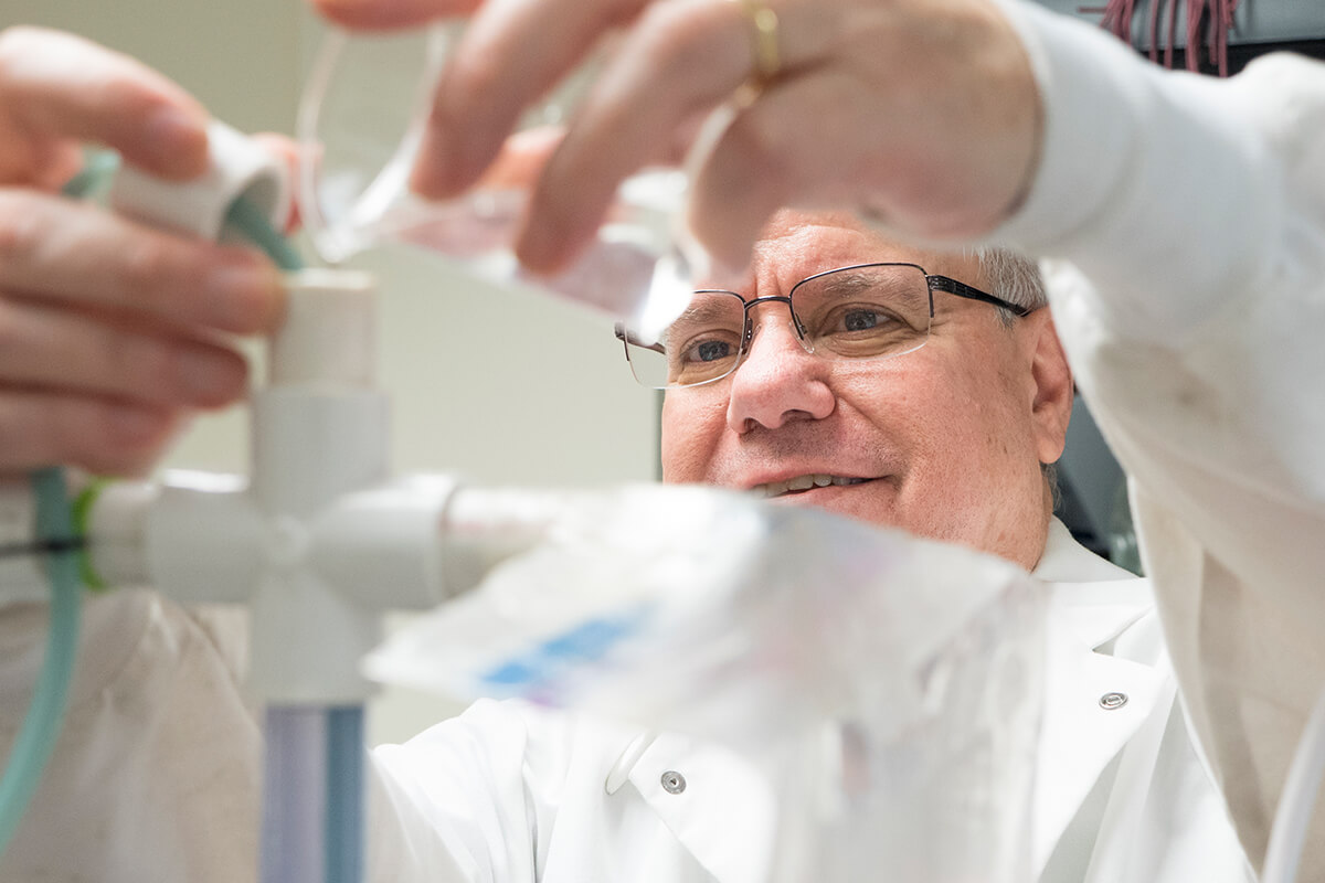 Researcher at NIA pours liquid in tube